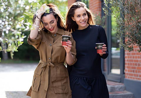 Alfredo Espresso Mood Bild - Zwei Frauen mit Alfredo Paper Cups